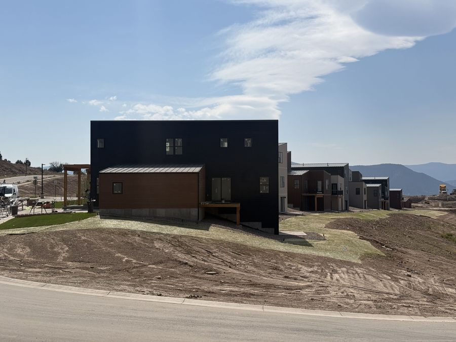 New construction lots mid-grading alongside finished sod lawns, showing landscape installation in progress